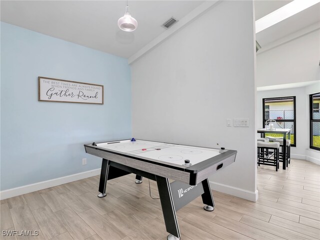 playroom featuring vaulted ceiling, baseboards, and light wood finished floors