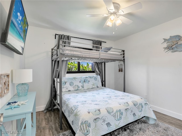 bedroom with baseboards, wood finished floors, and a ceiling fan