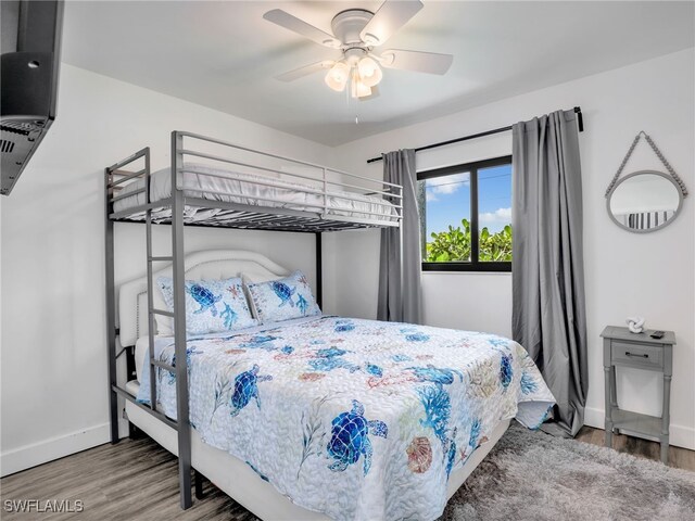 bedroom with baseboards, wood finished floors, and a ceiling fan