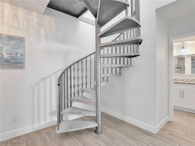 staircase featuring baseboards and wood finished floors