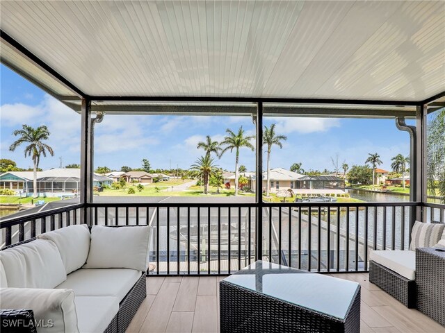wooden terrace featuring outdoor lounge area, a water view, and a residential view