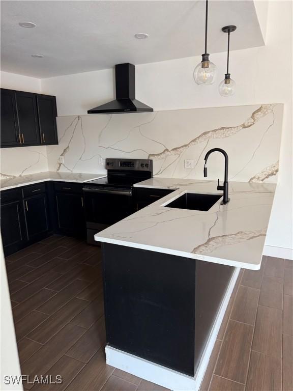 6321 Royal Woods Dr, Fort Myers, FL 33908 - kitchen featuring wall chimney exhaust hood, black range with electric stovetop, a sink, dark cabinets, and a peninsula