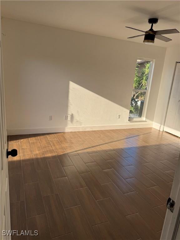 6321 Royal Woods Dr, Fort Myers, FL 33908 - empty room with wood tiled floors, ceiling fan, and baseboards