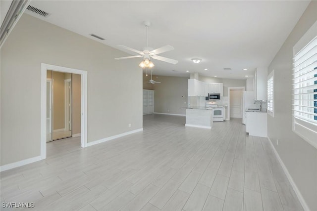 3613 Exuma Way, Naples, FL 34119 - unfurnished living room featuring ceiling fan, light wood-style floors, baseboards, recessed lighting, and a sink