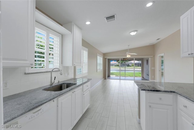 3613 Exuma Way, Naples, FL 34119 - kitchen with a sink, white dishwasher, vaulted ceiling, backsplash, and white cabinets