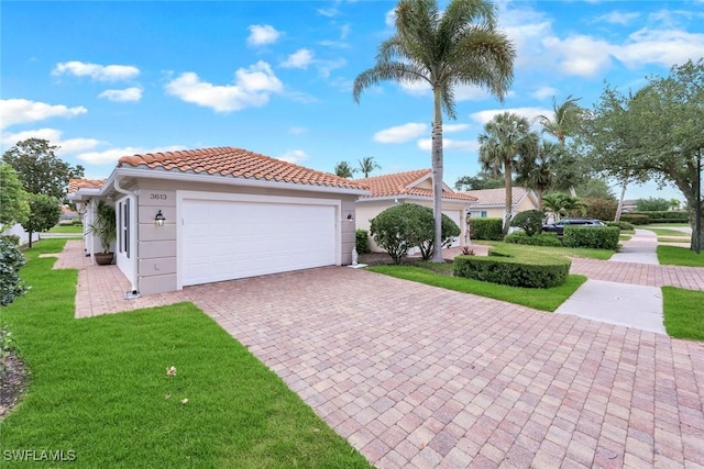 3613 Exuma Way, Naples, FL 34119 - mediterranean / spanish-style home featuring a front yard, a tiled roof, a garage, stucco siding, and decorative driveway