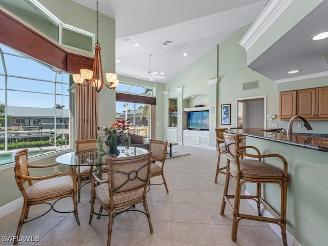 dining space featuring ceiling fan, built in shelves, baseboards, a high ceiling, and light tile patterned flooring