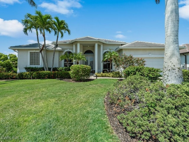 view of front facade featuring an attached garage, a front lawn, and stucco siding
