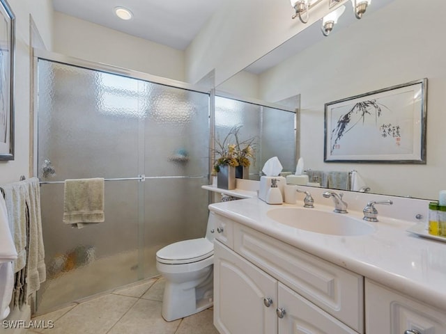 bathroom featuring tile patterned floors, a stall shower, toilet, and vanity