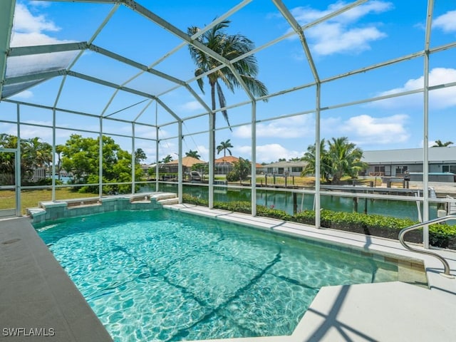 outdoor pool featuring a water view, glass enclosure, and a patio