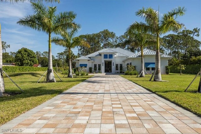 6145 Sea Grass Ln, Naples, FL 34116 - view of front of home featuring a front yard, stucco siding, driveway, and a standing seam roof