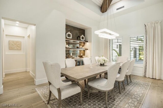 6145 Sea Grass Ln, Naples, FL 34116 - dining room featuring light wood-type flooring, baseboards, and a chandelier