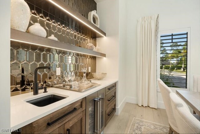 6145 Sea Grass Ln, Naples, FL 34116 - indoor wet bar featuring wine cooler, baseboards, and light wood-type flooring
