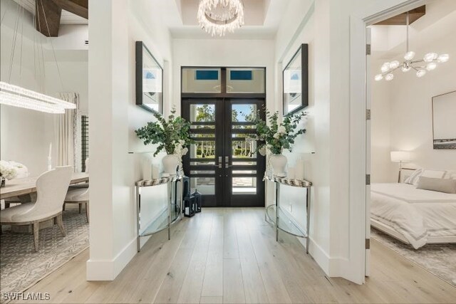 6145 Sea Grass Ln, Naples, FL 34116 - foyer featuring a chandelier, wood finished floors, french doors, and a towering ceiling