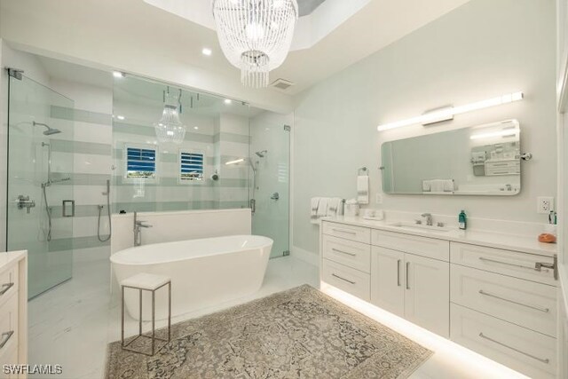 6145 Sea Grass Ln, Naples, FL 34116 - bathroom with a shower stall, vanity, a freestanding tub, and a chandelier