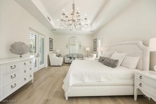 6145 Sea Grass Ln, Naples, FL 34116 - bedroom featuring a chandelier, a tray ceiling, access to exterior, and multiple windows
