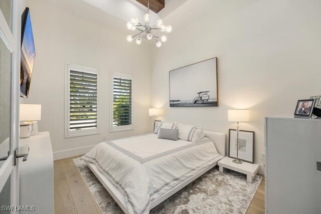 6145 Sea Grass Ln, Naples, FL 34116 - bedroom featuring a chandelier, light wood-style floors, and baseboards