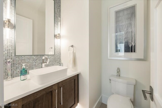 6145 Sea Grass Ln, Naples, FL 34116 - bathroom with backsplash, vanity, toilet, and baseboards