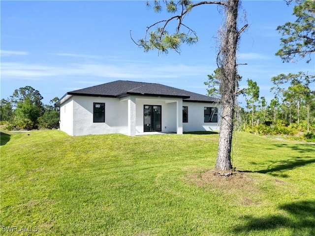 2815 32nd St W, Lehigh Acres, FL 33971 - rear view of property featuring stucco siding and a lawn