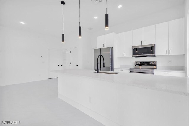 2815 32nd St W, Lehigh Acres, FL 33971 - kitchen with appliances with stainless steel finishes, a sink, recessed lighting, white cabinetry, and hanging light fixtures