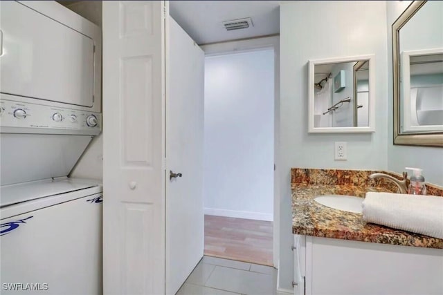 260 Southbay Dr Unit 103, Naples, FL 34108 - bathroom with estacked washer and dryer, vanity, tile patterned floors, and baseboards