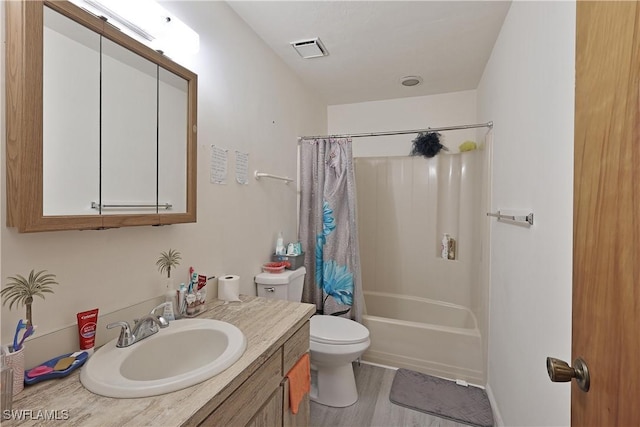 bathroom featuring toilet, vanity, wood finished floors, and shower / bath combo