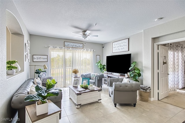 13160 Bella Casa Cir Unit 2115, Fort Myers, FL 33966 - living area featuring a ceiling fan, a textured ceiling, light tile patterned floors, arched walkways, and a textured wall