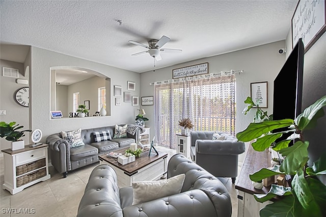 13160 Bella Casa Cir Unit 2115, Fort Myers, FL 33966 - living area with ceiling fan, arched walkways, and a textured ceiling