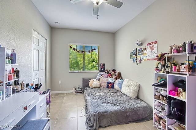 13160 Bella Casa Cir Unit 2115, Fort Myers, FL 33966 - bedroom with light tile patterned floors, a textured wall, a ceiling fan, and baseboards