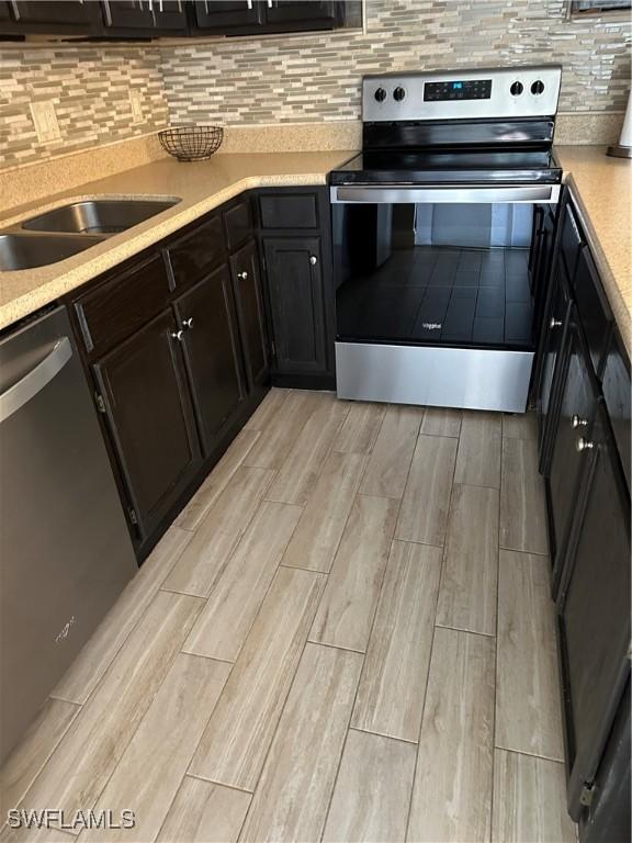5226 Cedarbend Dr Unit 2, Fort Myers, FL 33919 - kitchen featuring appliances with stainless steel finishes, wood tiled floors, light countertops, and backsplash