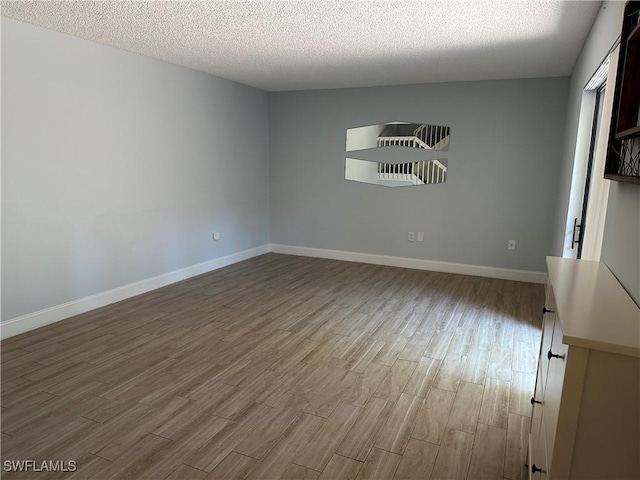 5226 Cedarbend Dr Unit 2, Fort Myers, FL 33919 - spare room with wood finished floors, a textured ceiling, and baseboards