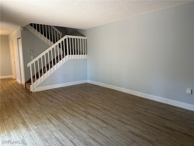 5226 Cedarbend Dr Unit 2, Fort Myers, FL 33919 - spare room featuring wood finished floors, stairway, baseboards, and a textured ceiling