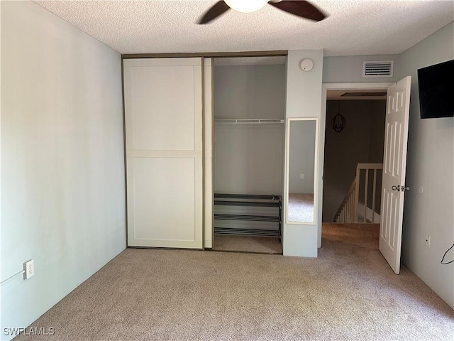 5226 Cedarbend Dr Unit 2, Fort Myers, FL 33919 - unfurnished bedroom featuring carpet flooring, a closet, a textured ceiling, and a ceiling fan