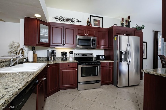2386 Magnolia Ave Unit 7801, Naples, FL 34112 - kitchen featuring stainless steel appliances, reddish brown cabinets, a sink, light tile patterned floors, and light stone counters