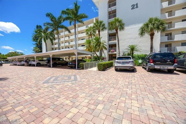 21 High Point Cir E Unit 502, Naples, FL 34103 - view of apartment building / complex featuring covered and uncovered parking