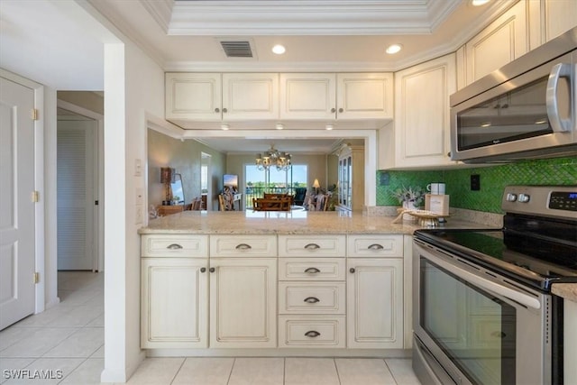21 High Point Cir E Unit 502, Naples, FL 34103 - kitchen with appliances with stainless steel finishes, crown molding, a chandelier, light tile patterned flooring, and light stone countertops