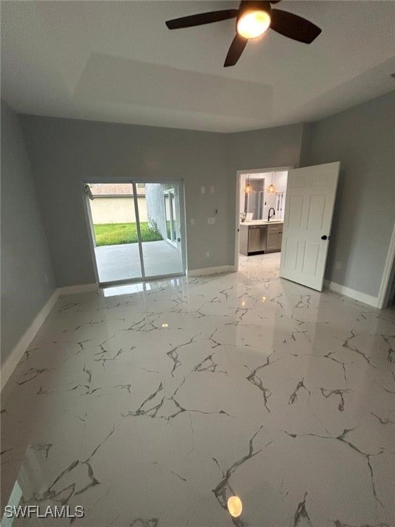empty room featuring baseboards, ceiling fan, and light marble finish floors