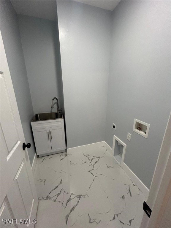 clothes washing area featuring cabinet space, baseboards, light marble finish floors, and washer hookup