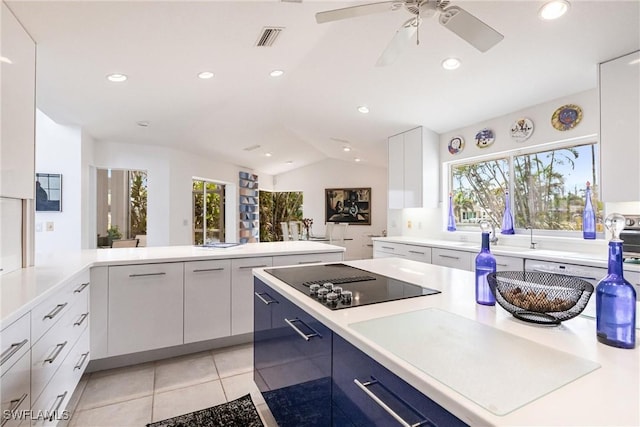 12439 Prather Ave, Port Charlotte, FL 33981 - kitchen featuring black electric stovetop, lofted ceiling, modern cabinets, light countertops, and light tile patterned floors