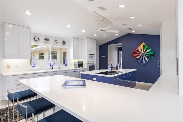 12439 Prather Ave, Port Charlotte, FL 33981 - kitchen with a kitchen island, white appliances, modern cabinets, vaulted ceiling, and white cabinetry