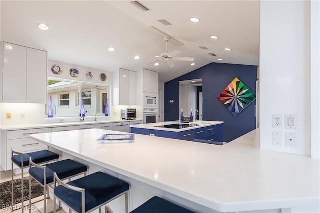 12439 Prather Ave, Port Charlotte, FL 33981 - kitchen with white appliances, modern cabinets, white cabinets, a breakfast bar area, and a center island with sink