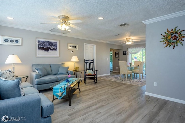 1303 Thompson St, North Fort Myers, FL 33903 - living room featuring a ceiling fan, a textured ceiling, light wood-type flooring, ornamental molding, and baseboards