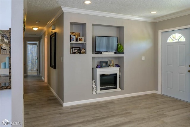 1303 Thompson St, North Fort Myers, FL 33903 - entryway with ornamental molding, wood finished floors, a textured ceiling, a glass covered fireplace, and baseboards