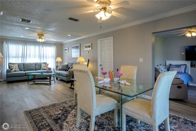1303 Thompson St, North Fort Myers, FL 33903 - dining room with ceiling fan, a textured ceiling, wood finished floors, crown molding, and baseboards