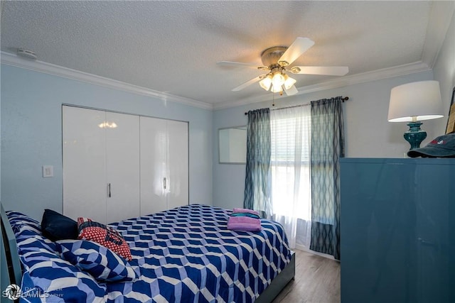 1303 Thompson St, North Fort Myers, FL 33903 - bedroom with a closet, wood finished floors, crown molding, a textured ceiling, and a ceiling fan