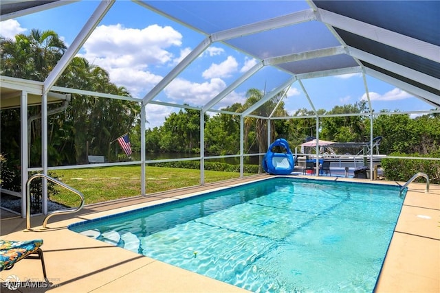 1303 Thompson St, North Fort Myers, FL 33903 - outdoor pool featuring a lawn, a patio, glass enclosure, and view of scattered trees