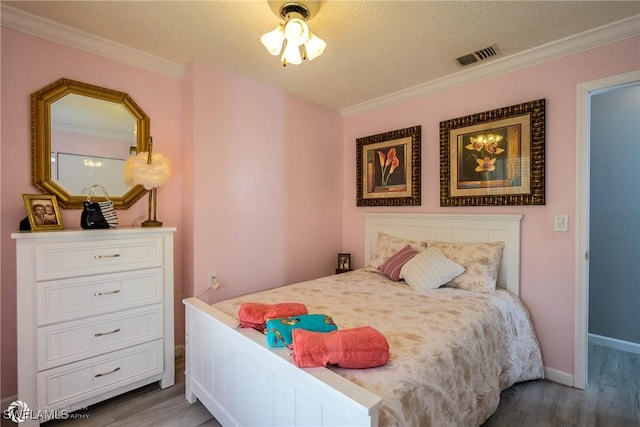 1303 Thompson St, North Fort Myers, FL 33903 - bedroom with wood finished floors, ornamental molding, baseboards, and a textured ceiling