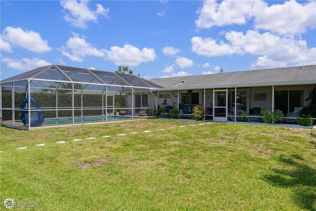 1303 Thompson St, North Fort Myers, FL 33903 - rear view of property featuring an outdoor pool, a lawn, and glass enclosure