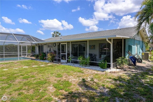 1303 Thompson St, North Fort Myers, FL 33903 - back of house featuring central AC unit, a lawn, an outdoor pool, stucco siding, and glass enclosure