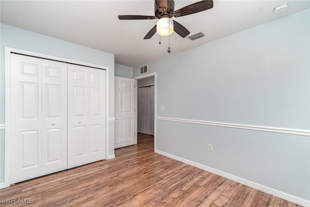 unfurnished bedroom with light wood finished floors, baseboards, a closet, and a ceiling fan